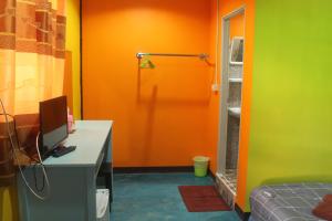 a room with an orange door and a desk with a computer at Rc Guest House in Phi Phi Islands