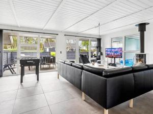 a living room with black leather furniture and a piano at 5 star holiday home in Nordborg in Nordborg +32 photos