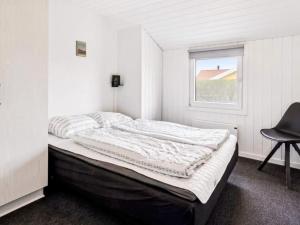 a bed in a room with a window and a chair at 5 star holiday home in Nordborg in Nordborg