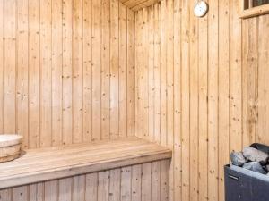 a wooden sauna with a clock on the wall at 5 star holiday home in Nordborg in Nordborg