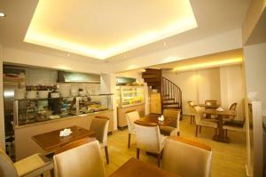 イズミールにあるSimal Butik Hotelのテーブルと椅子のあるレストラン、キッチンが備わります。