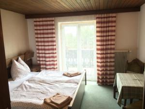 Un dormitorio con una cama y una ventana con toallas. en Gasthof Tennenblick en Werfenweng