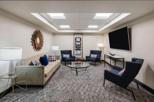 a living room with a couch and chairs and a tv at Stone Hill Norman, Trademark Collection by Wyndham in Norman