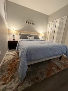 a bedroom with a bed and two lamps and two doors at Almost Heaven - Cozy 2BDRM APT near Heritage Park,Spruce Meadows & Banff-SW Calgary in Calgary +55 photos