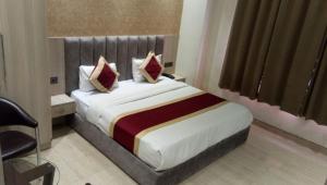 a hotel room with a large bed with red pillows at Amber Continental in Bareilly