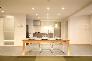 a kitchen with a wooden table and two chairs at BROOMSTAY Umeda west in Osaka +36 photos