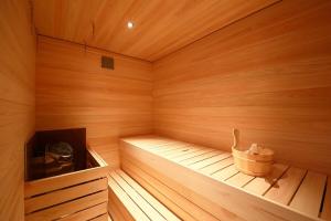 a small wooden sauna with a bucket in it at BROOMSTAY Umeda west in Osaka
