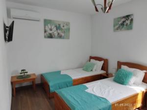 a room with two beds and a table with a bedskirts at Cazare Stefan in Curtea de Argeş