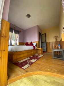 une chambre avec un grand lit avec des meubles en bois dans l'établissement Gombo Hideaway, à Nagarkot 12 autres photos