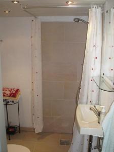 y baño con cortina de ducha y lavamanos. en Strandhuset Holiday Home en Glyngøre