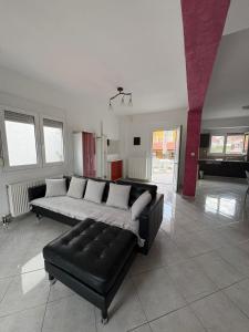 a living room with a black leather couch at Villa Marianna in Nea Vrasna