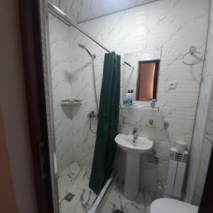 y baño con ducha, lavamanos y ducha. en Guest House Javlonbek, en Samarkand