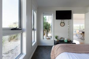 een slaapkamer met een bed en een groot raam bij Low Head Coastal Haven: Your Seaside Escape in Low Head +45 foto's