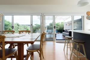 een keuken en eetkamer met een houten tafel en stoelen bij Low Head Coastal Haven: Your Seaside Escape in Low Head