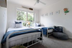 een slaapkamer met twee bedden en een raam bij Low Head Coastal Haven: Your Seaside Escape in Low Head