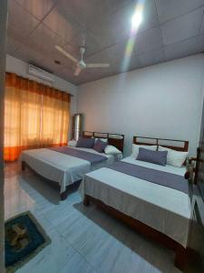 a bedroom with two beds and a ceiling at Wijaya Home Stay in Anuradhapura