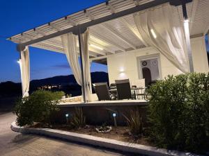 a white pergola on a house at night at Achivadolimni Beach Seaview in Provatas +42 photos