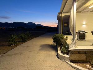 a driveway leading to a house with mountains in the background at Achivadolimni Beach Seaview in Provatas