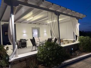 a pergola with a table and chairs on a patio at Achivadolimni Beach Seaview in Provatas