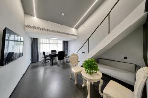 a living room with a couch and a table and chairs at ZhangJiaJieWuLingYuan栖见云舍Hotel in Hanqiyu