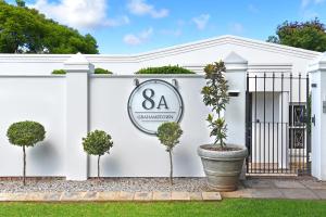 a white fence with a address sign on it at 8A Grahamstown by The Oyster Collection in Grahamstown