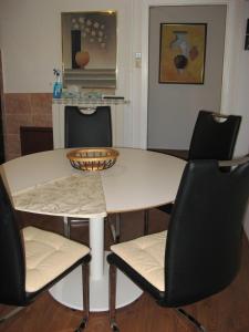 ein weißer Tisch mit zwei Stühlen und ein Tisch mit einer Schüssel darauf in der Unterkunft Apartment Alea in Portorož