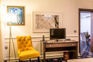 a room with a desk with a tv and a chair at Hotel Palace Marina Dinevi in Sveti Vlas +153 photos