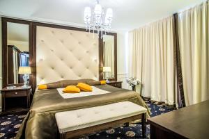 a bedroom with a large bed with yellow pillows on it at Hotel Palace Marina Dinevi in Sveti Vlas