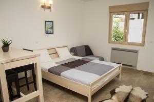 a bedroom with a bed and a desk and a window at Apartments Brežanin in Sutomore