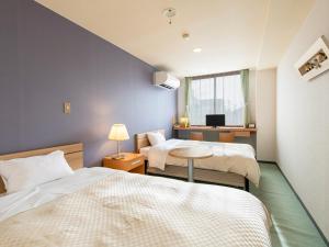 a hotel room with two beds and a television at Houei Ryokan in Fukui +61 photos