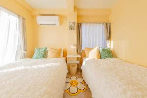 een slaapkamer met twee bedden en een raam bij 3-minute walk from Shin-Okubo Station -Shobi Buildding- in Tokyo