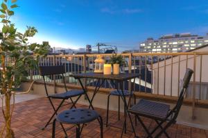 een tafel en stoelen op een balkon met uitzicht bij 3-minute walk from Shin-Okubo Station -Shobi Buildding- in Tokyo