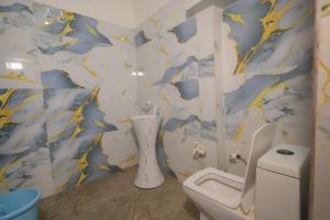 a bathroom with a toilet and blue and yellow wallpaper at Shri Radha Raman Ji Seva Sadan in Mathura +36 photos
