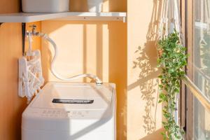 een witte wasmachine naast een raam bij 3-minute walk from Shin-Okubo Station -Shobi Buildding- in Tokyo +22 foto's