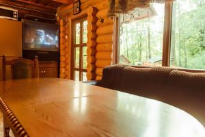 IlʼnytsyaCottage Teremok的一间带木桌和电视的用餐室