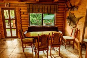 IlʼnytsyaCottage Teremok的小屋内带桌椅的用餐室