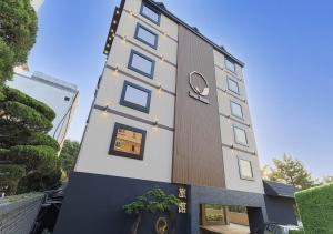 釜山Mandeok Denbasta Ryokan的侧面有钟的建筑物