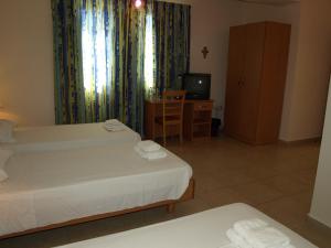 a hotel room with two beds and a television at Rivotorto Retreat House in Birkirkara