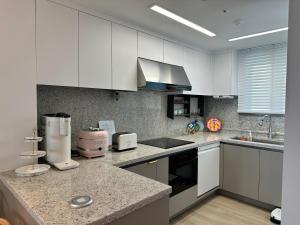 a kitchen with white cabinets and a counter top at 킨텍스 홍대 서울역 김포공항 고양종합운동장- Foreigner Only in Goyang