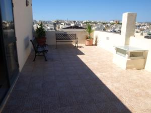 a balcony with a table and benches on a building at Rivotorto Retreat House in Birkirkara