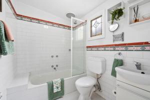 a bathroom with a toilet and a shower and a sink at Wyreema, Heritage Cottage in Geelong West +42 photos