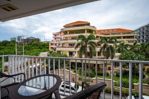 a balcony with two chairs and a building at New Nordic Suites 2 by Apartwell in Pattaya South