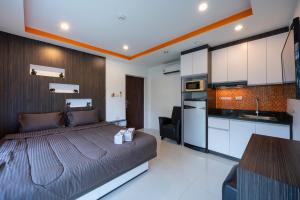 a bedroom with a large bed and a kitchen at New Nordic Suites 2 by Apartwell in Pattaya South