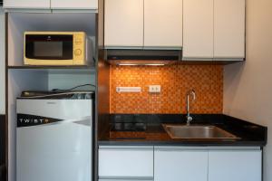 a kitchen with a sink and a microwave at New Nordic Suites 2 by Apartwell in Pattaya South +14 photos