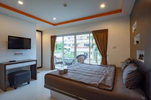 a bedroom with a large bed and a balcony at New Nordic Suites 2 by Apartwell in Pattaya South