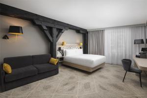 a hotel room with a bed and a couch at Hilton Garden Inn Paris La Villette in Paris +51 photos