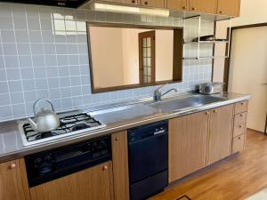 a kitchen with a sink and a stove top oven at いちほの宿 友秀 in Makinohara +8 photos