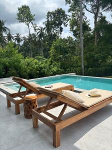 a wooden picnic table next to a swimming pool at Villa Lamai 4 bedrooms in Koh Samui  +7 photos