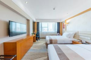 a hotel room with two beds and a flat screen tv at 深圳四川宾馆-福田华强北&双地铁口直达&免费停车 in Shenzhen