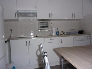 uma cozinha com armários brancos e uma bancada em Appartement L'oranger em Pégomas